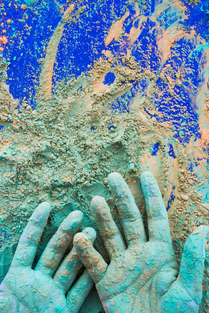 close-up-hand-painted-with-holi-color-powder-blue-background-min